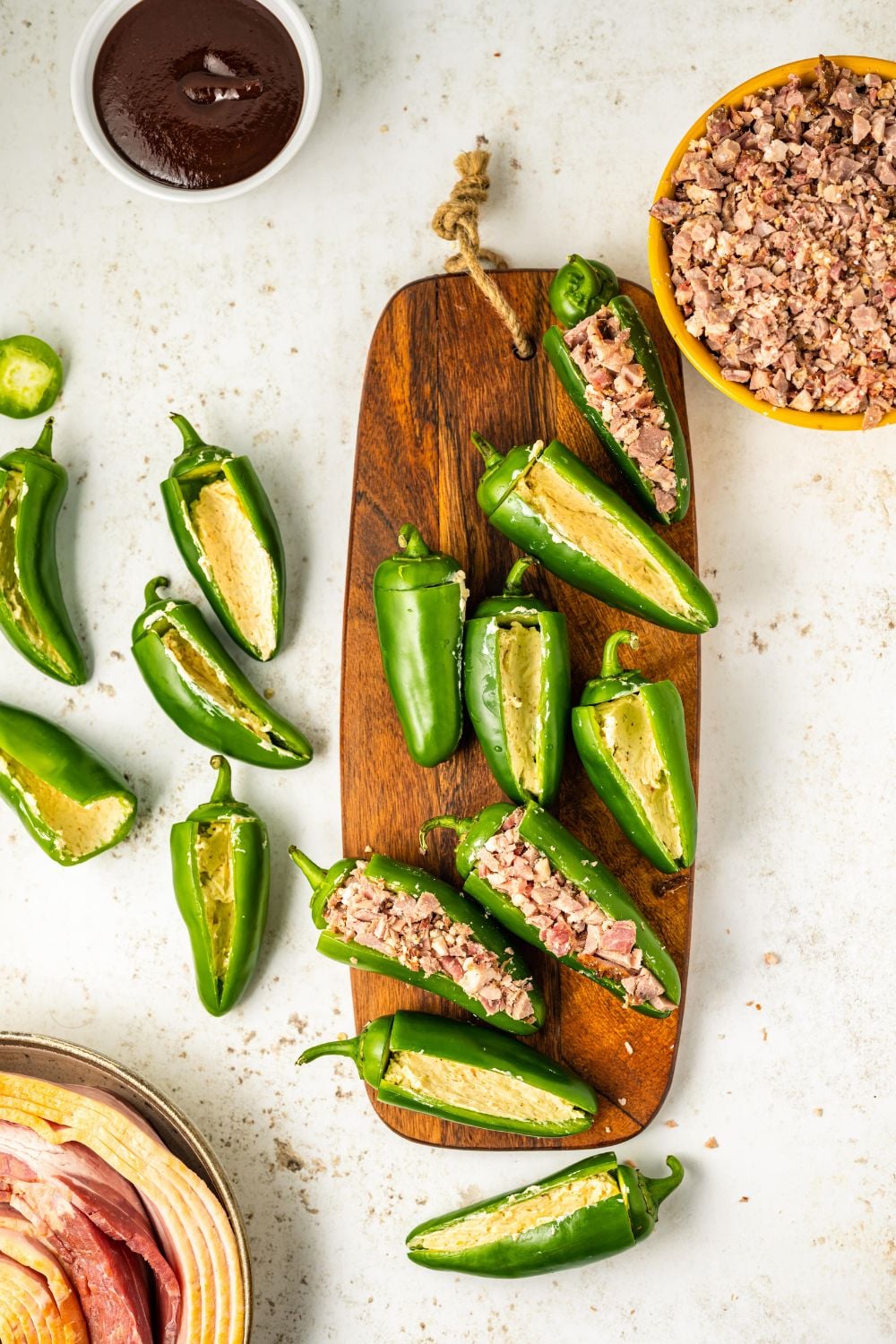jalapenos stuffed with cream cheese and brisket sitting on a cutting board on table
