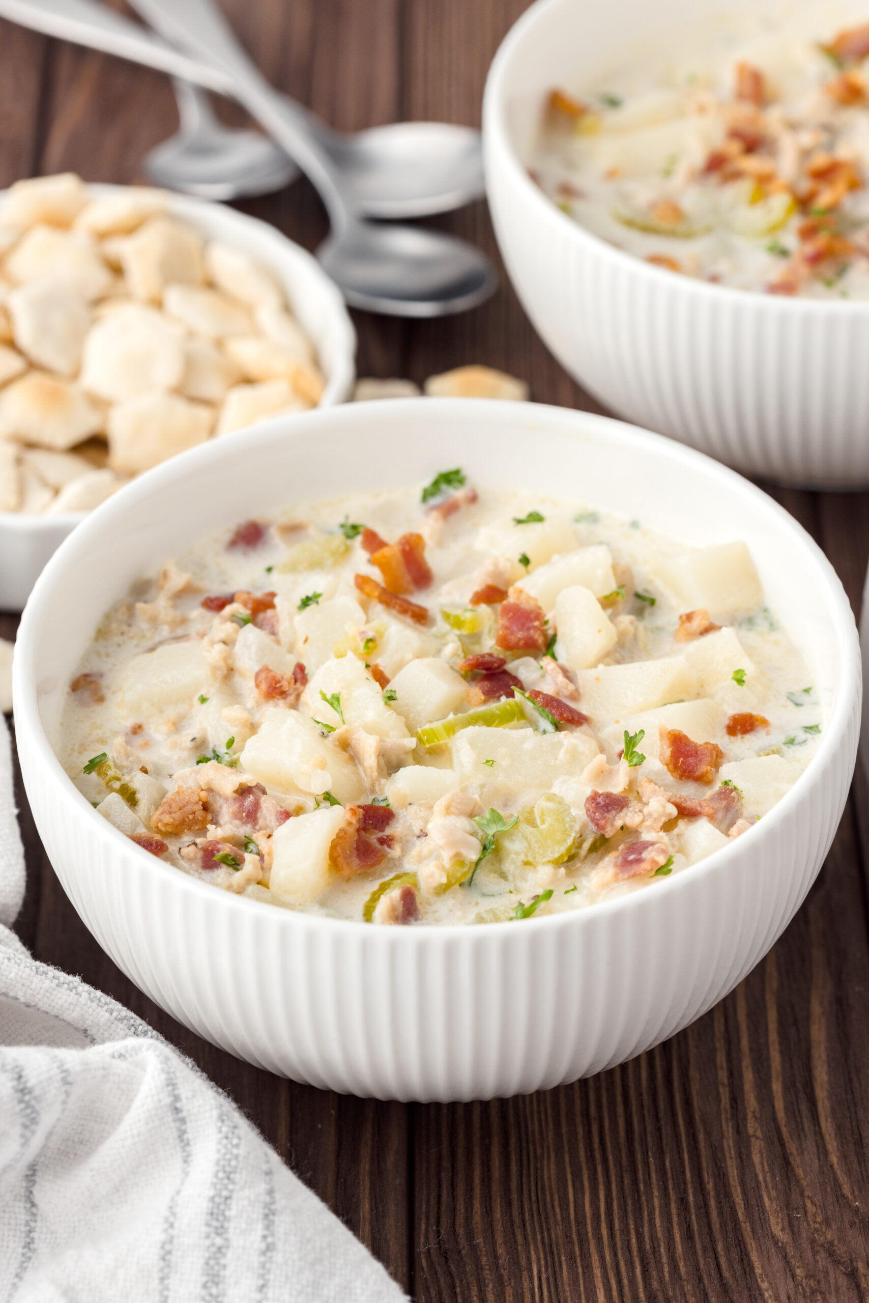 Clam chowder in a white bowl on a wooden table