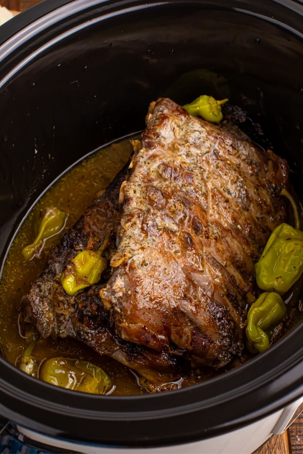 Slow Cooker Mississippi Ribs in a slow cooker with peppers and juice around them
