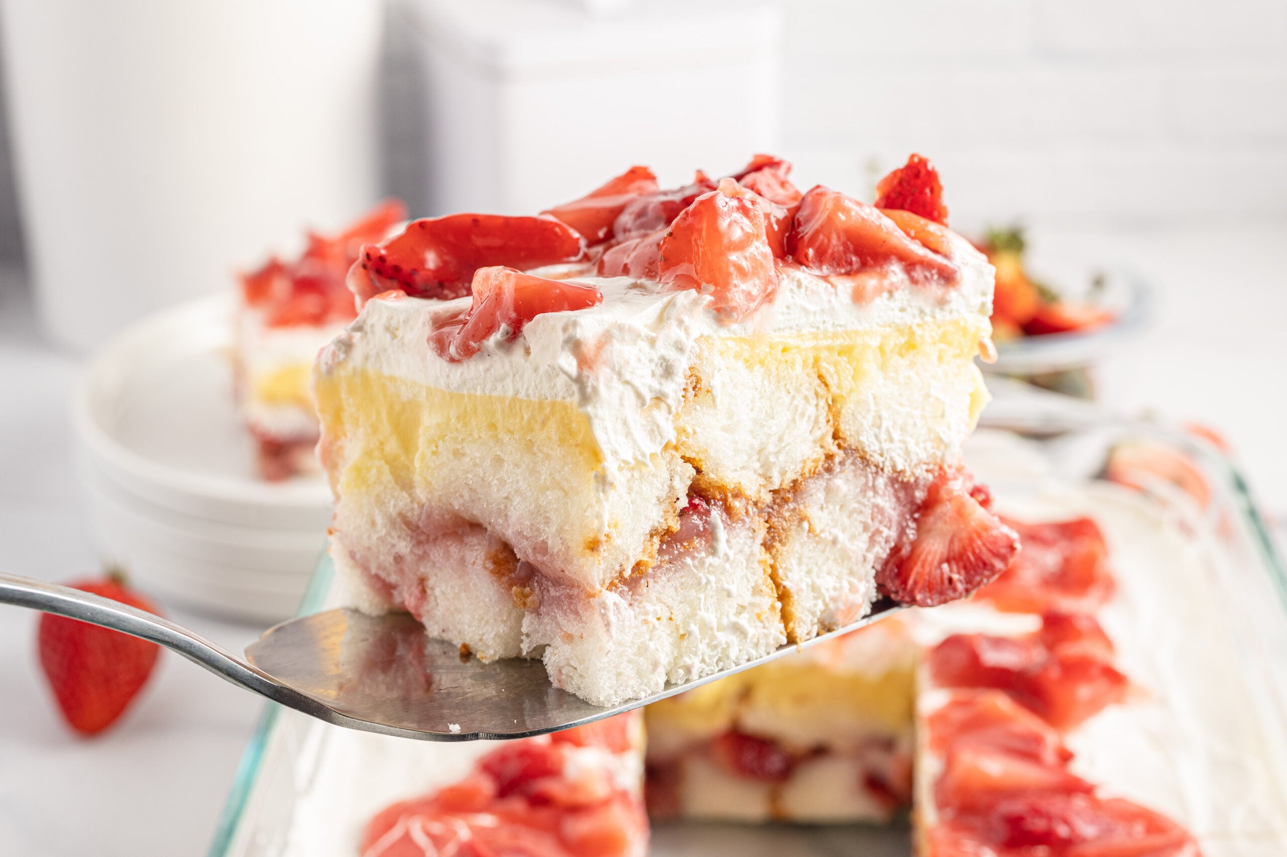 Strawberry Heaven On Earth Cake being lifted out of cake pan with a spatula