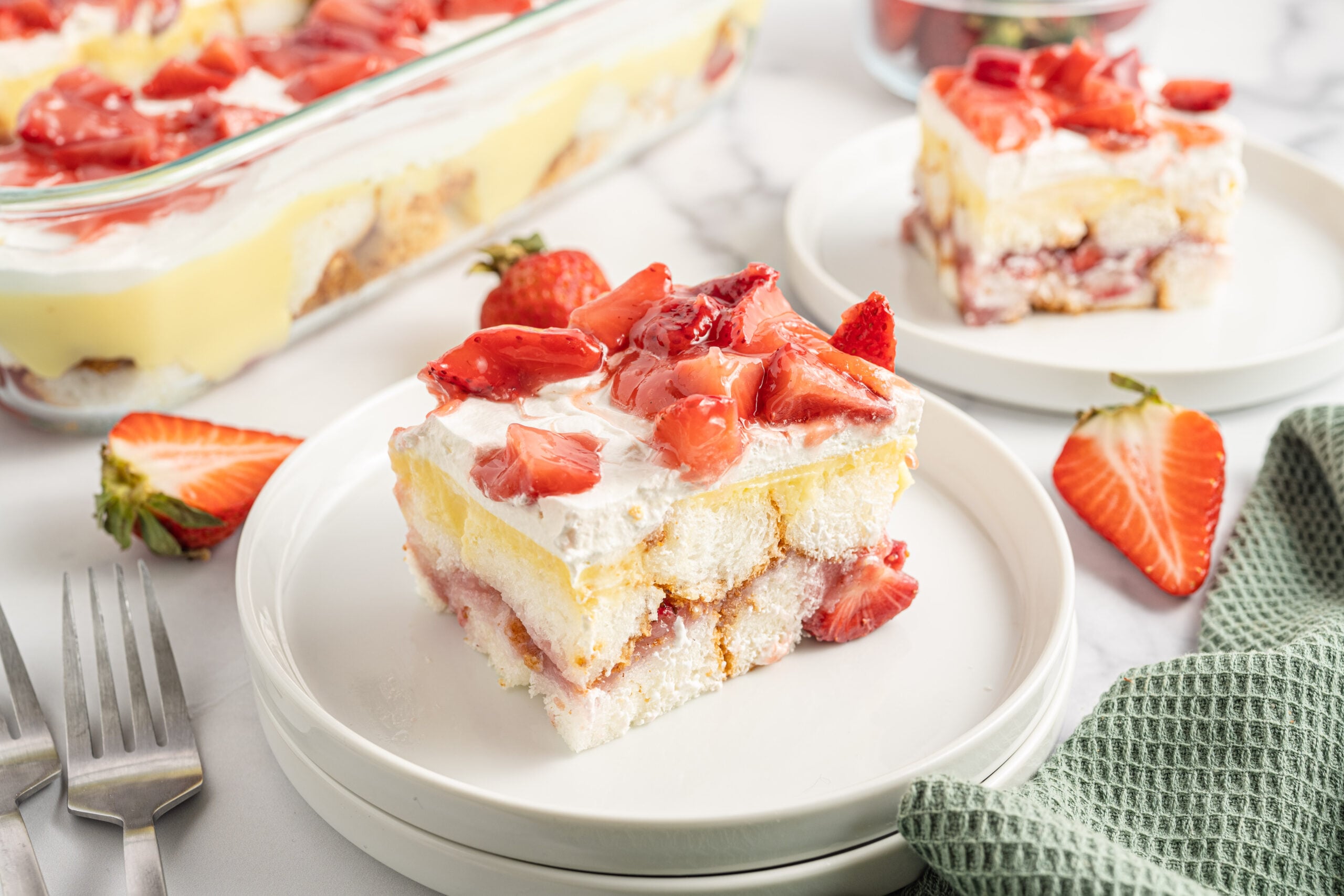 Strawberry Heaven On Earth Cake on a white plate topped with sliced strawberries