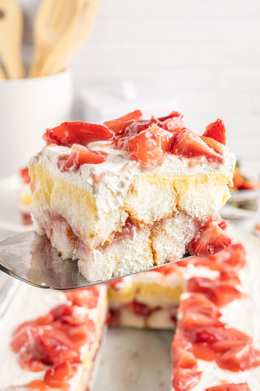 Strawberry Heaven On Earth Cake being lifted out of cake pan with a spatula
