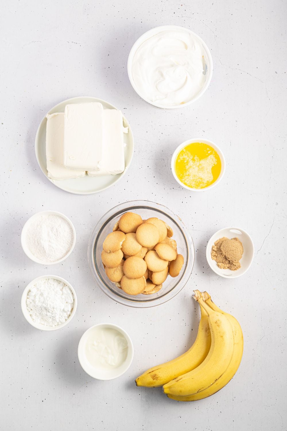 banana pudding cheesecake ingredients in single serve bowls on table to showcase all ingredients used
