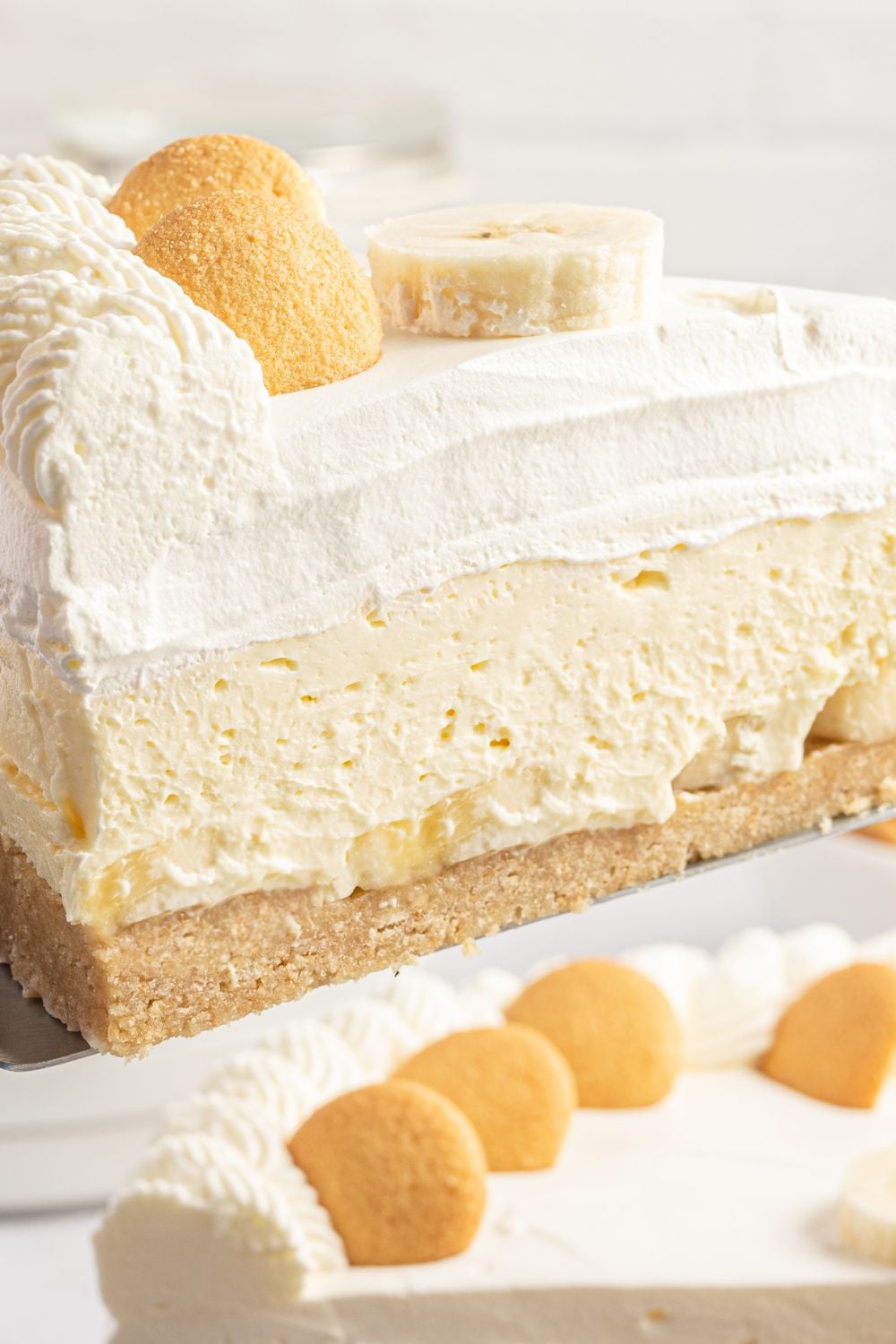 slice of banana cheesecake on spatula to showcase the layers of the cheesecake