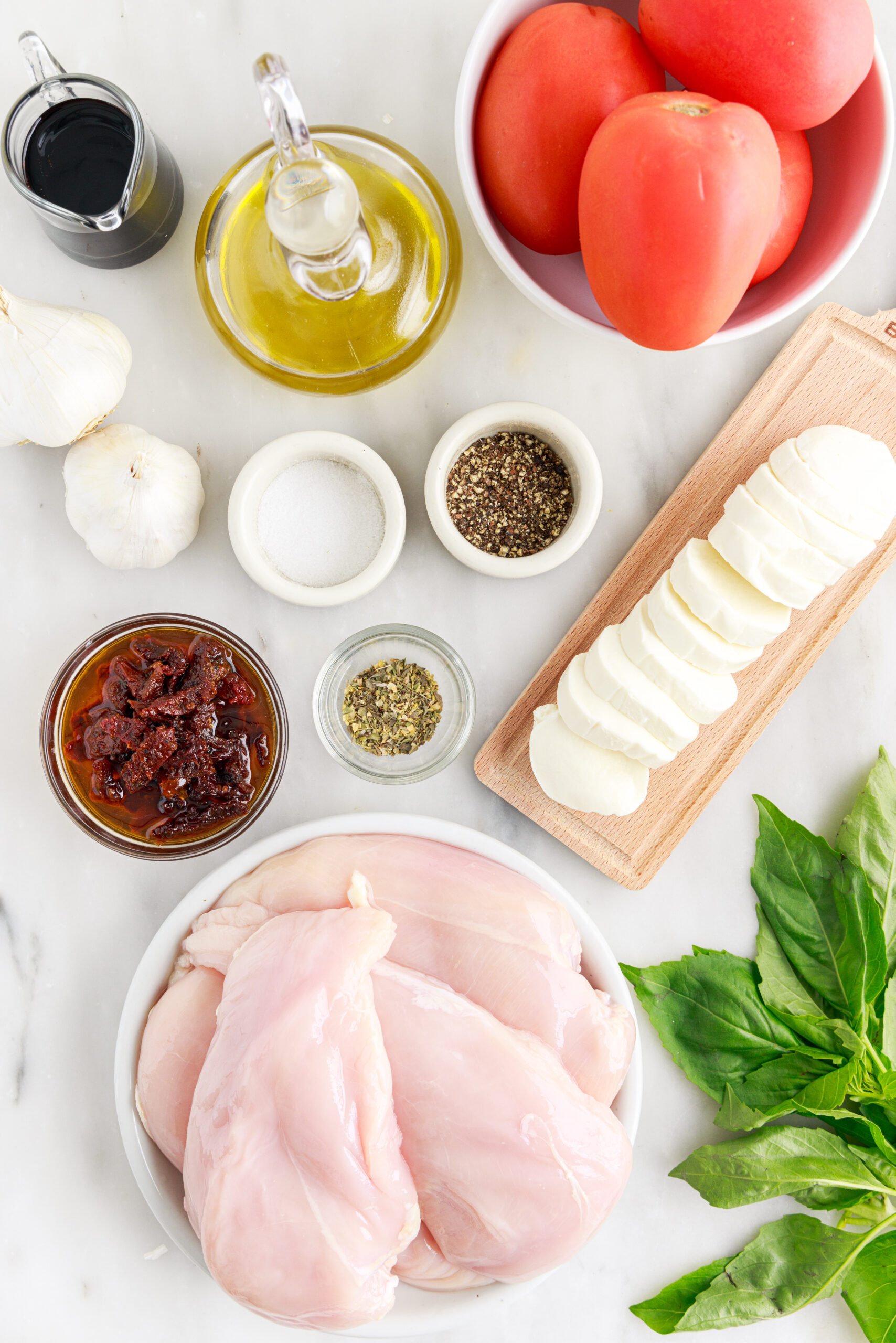 Caprese Stuffed Chicken ingredients sitting on table in single serve containers to show each ingredient 
