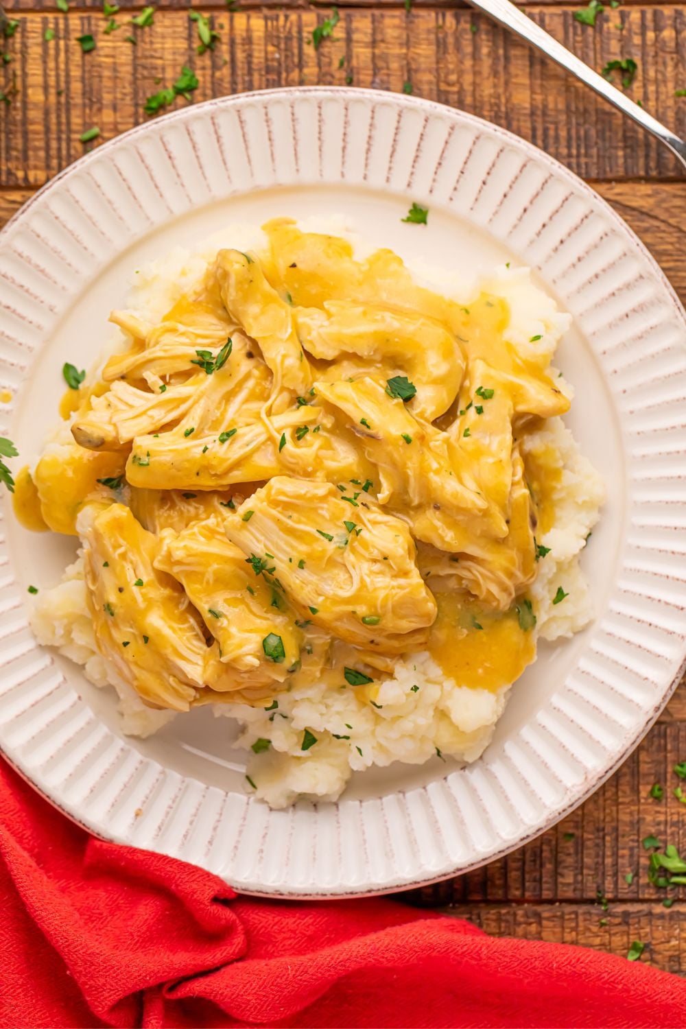 Chicken and Gravy with mashed potatoes on a plate sitting on a table 