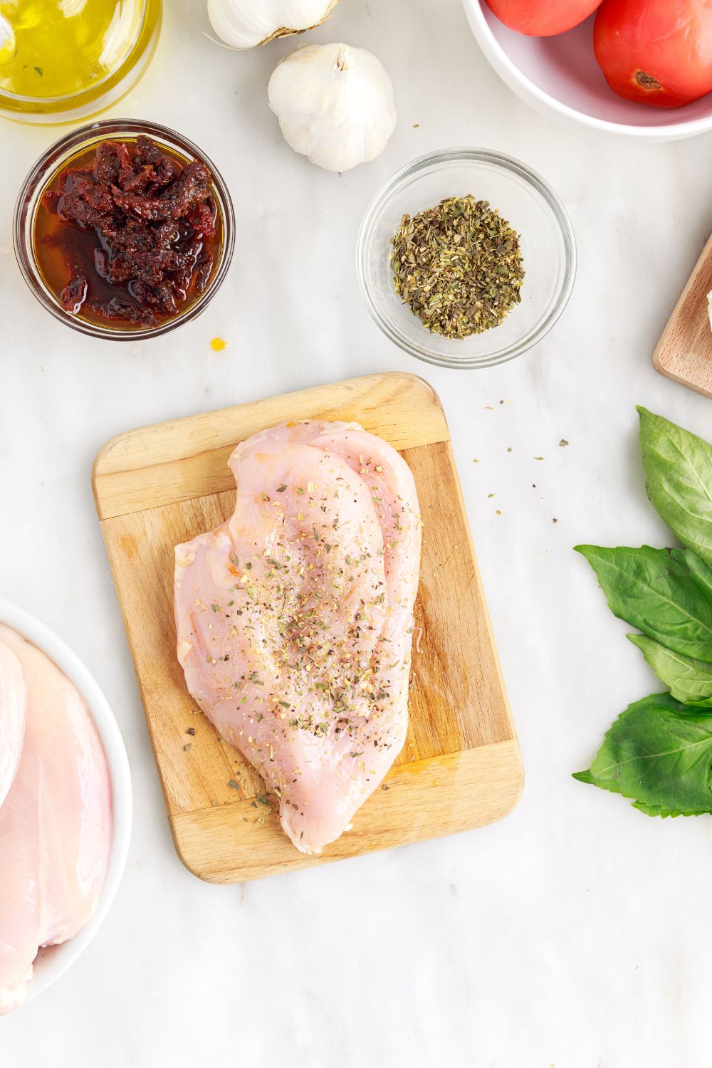 seasoned raw chicken on cutting board 