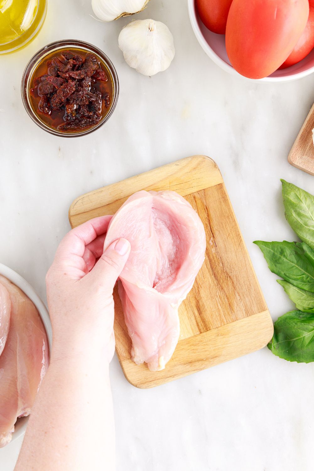 opening up the raw chicken to show the butterfly center