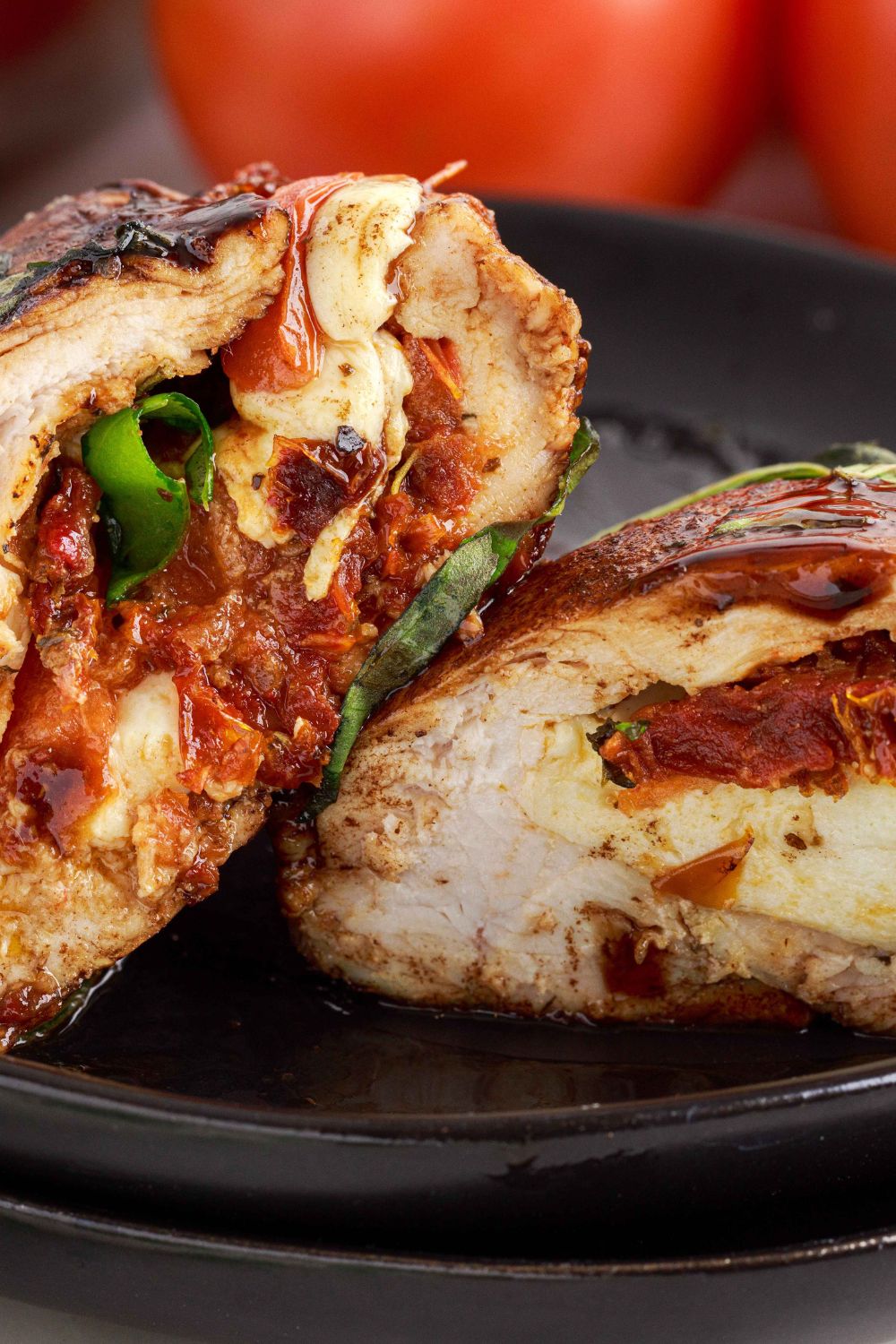 Caprese Stuffed Chicken cut in half and placed on a plate to showcase the filling 