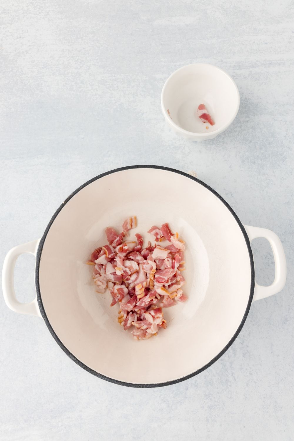 raw bacon in a stock pot sitting on table