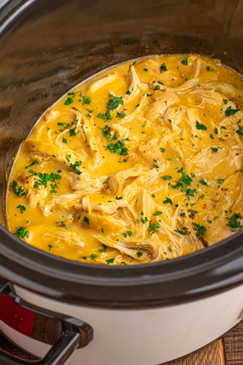side view of a Crock Pot with Chicken and Gravy it in sitting on table