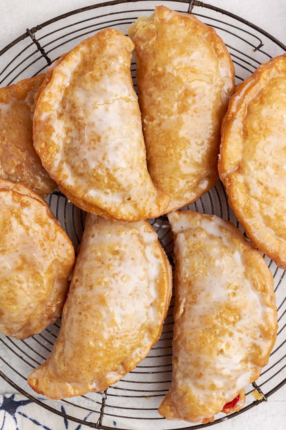 hand pies spread out on a cooling rack on marble counter top
