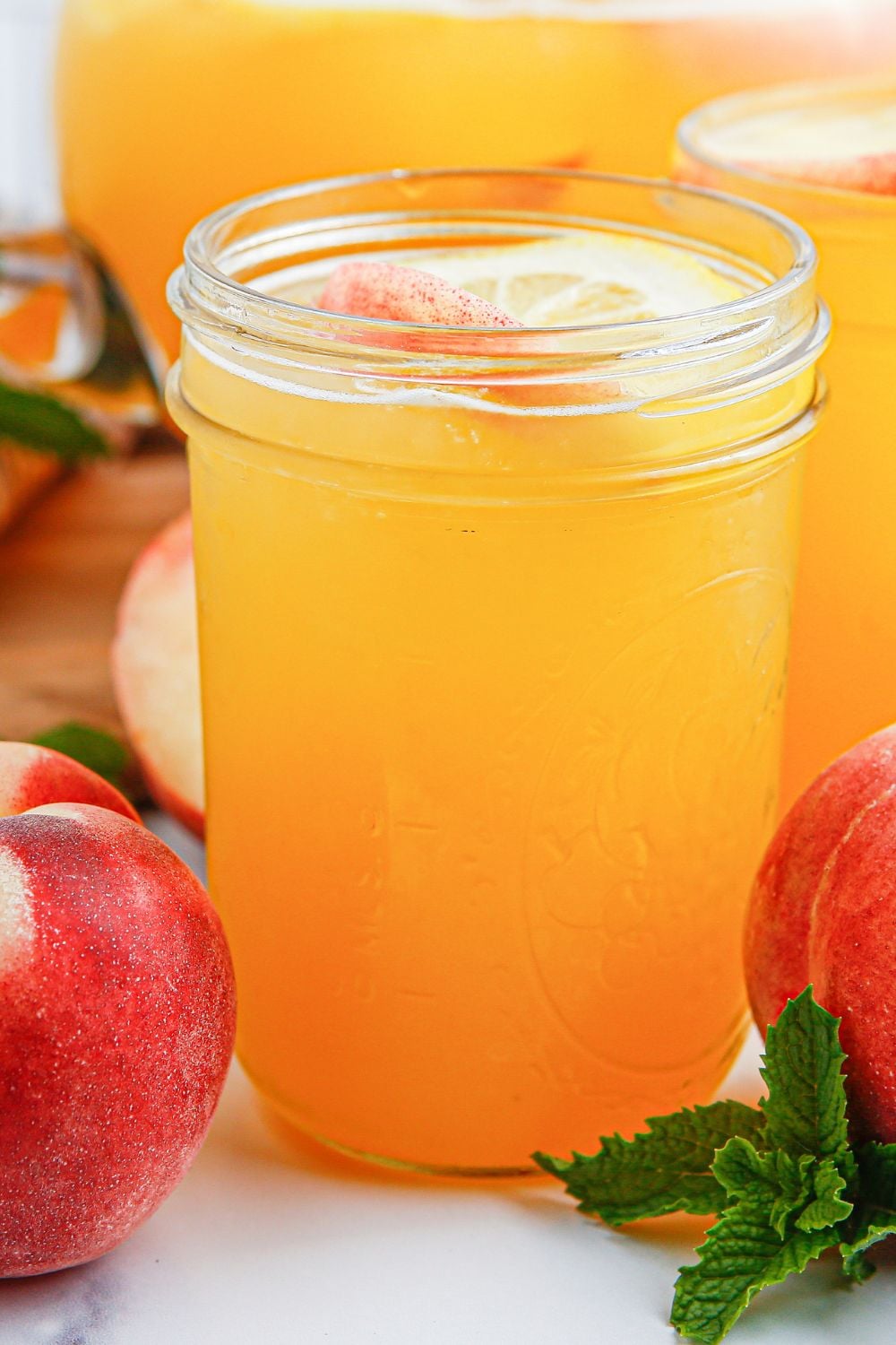 fresh peach lemonade in mason jar glasses sitting on table