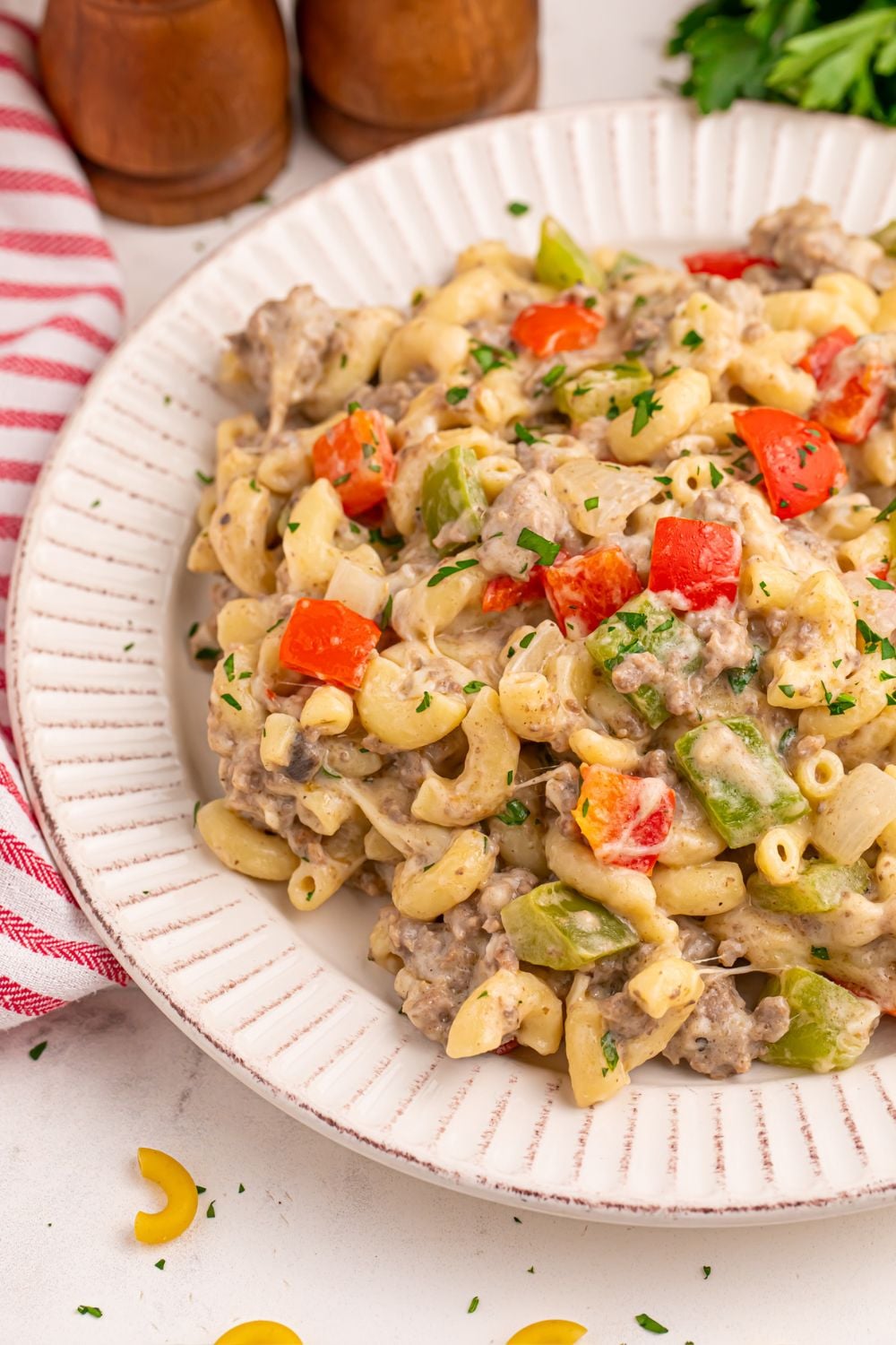 side view of plate on table with philly cheesesteak pasta on the plate