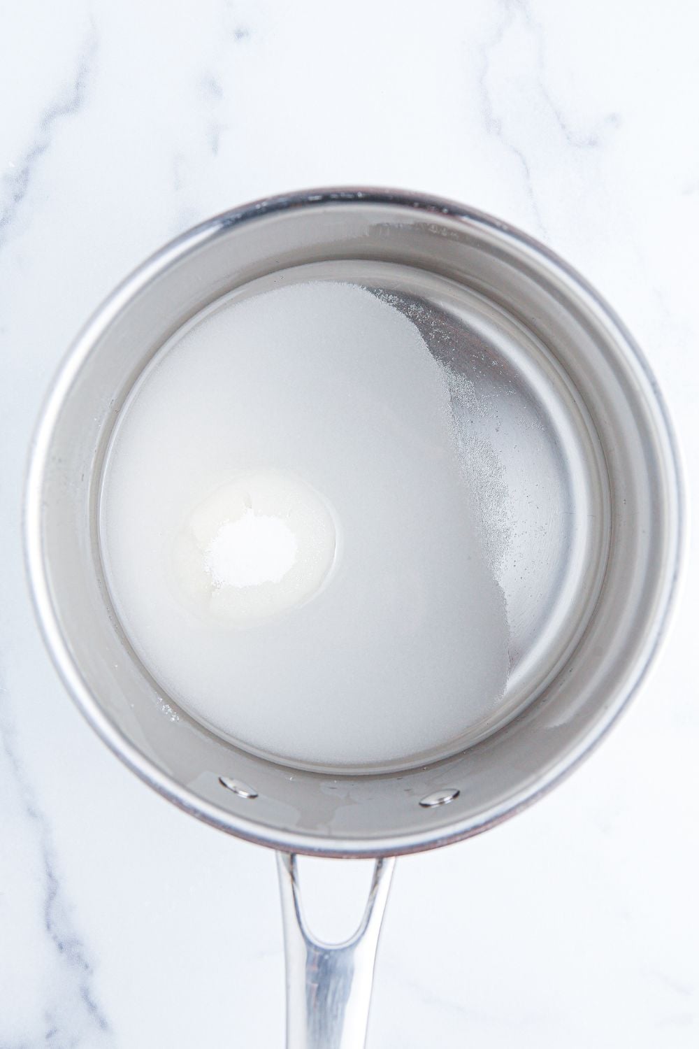 sugar water in a small saucepan sitting on table