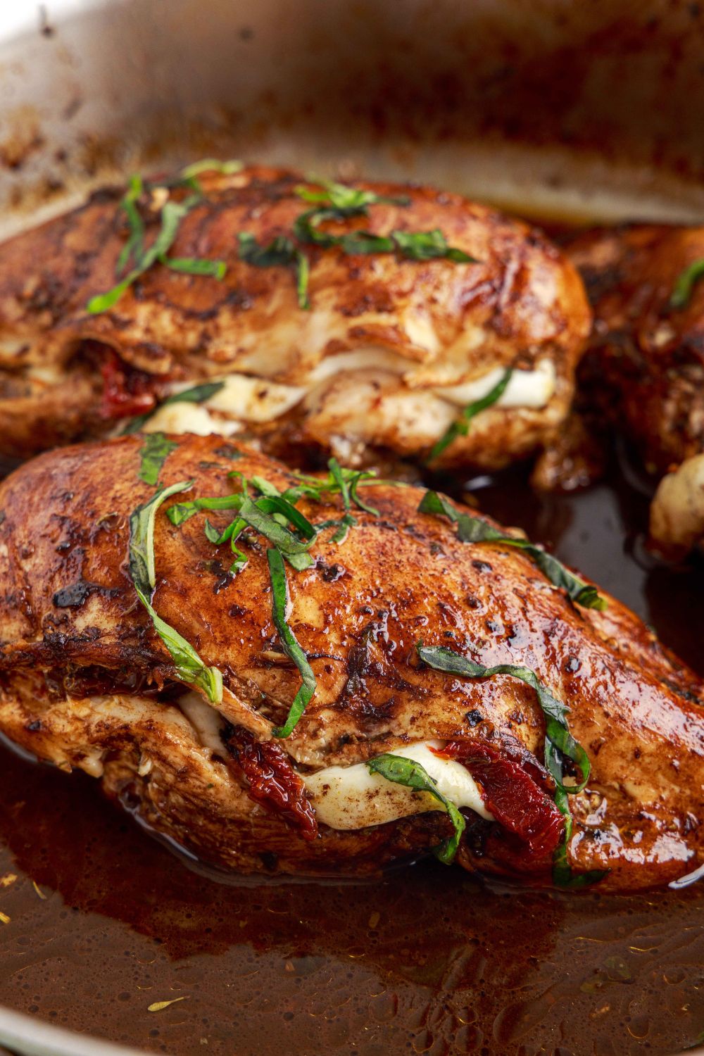 Caprese Stuffed Chicken sitting in pan showing it on the side view 