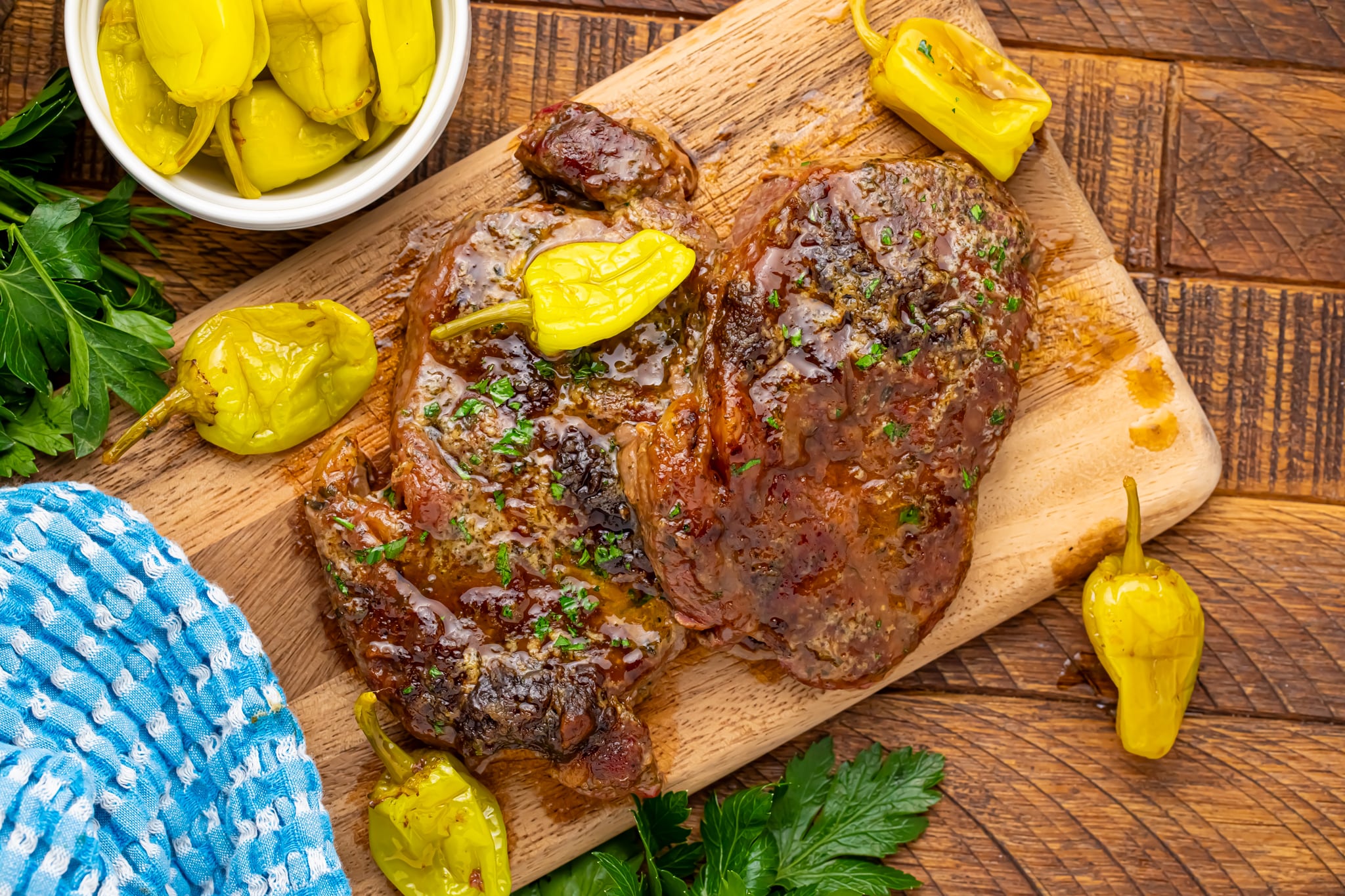 Slow cooker Mississippi ribeye steaks on a wooden cutting board showing how juicy they came out