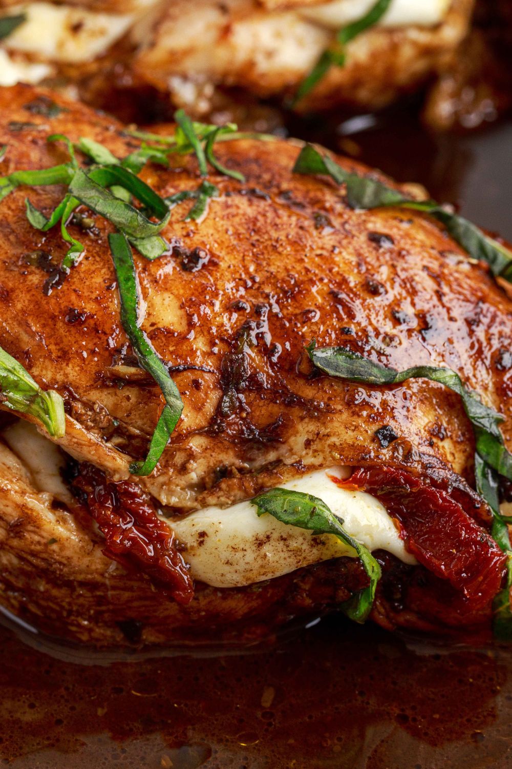 Caprese Stuffed Chicken on a plate showing the fresh herbs on top and glaze 