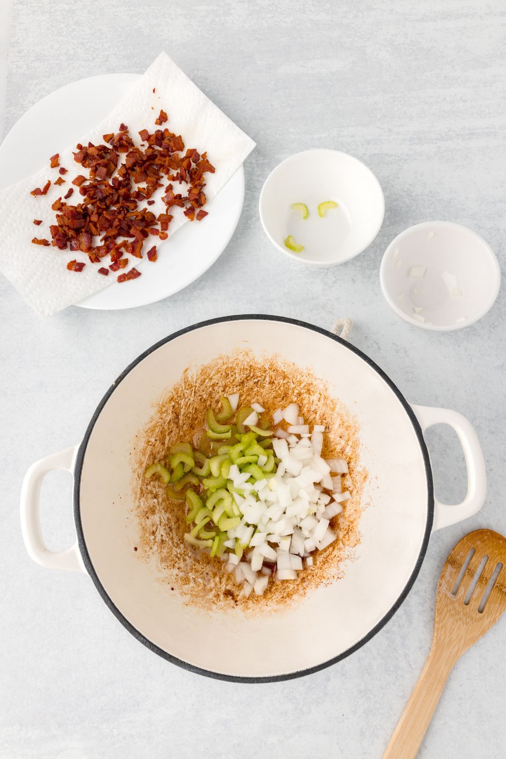 diced bacon, and onions and celery being sauted in a stockpot 