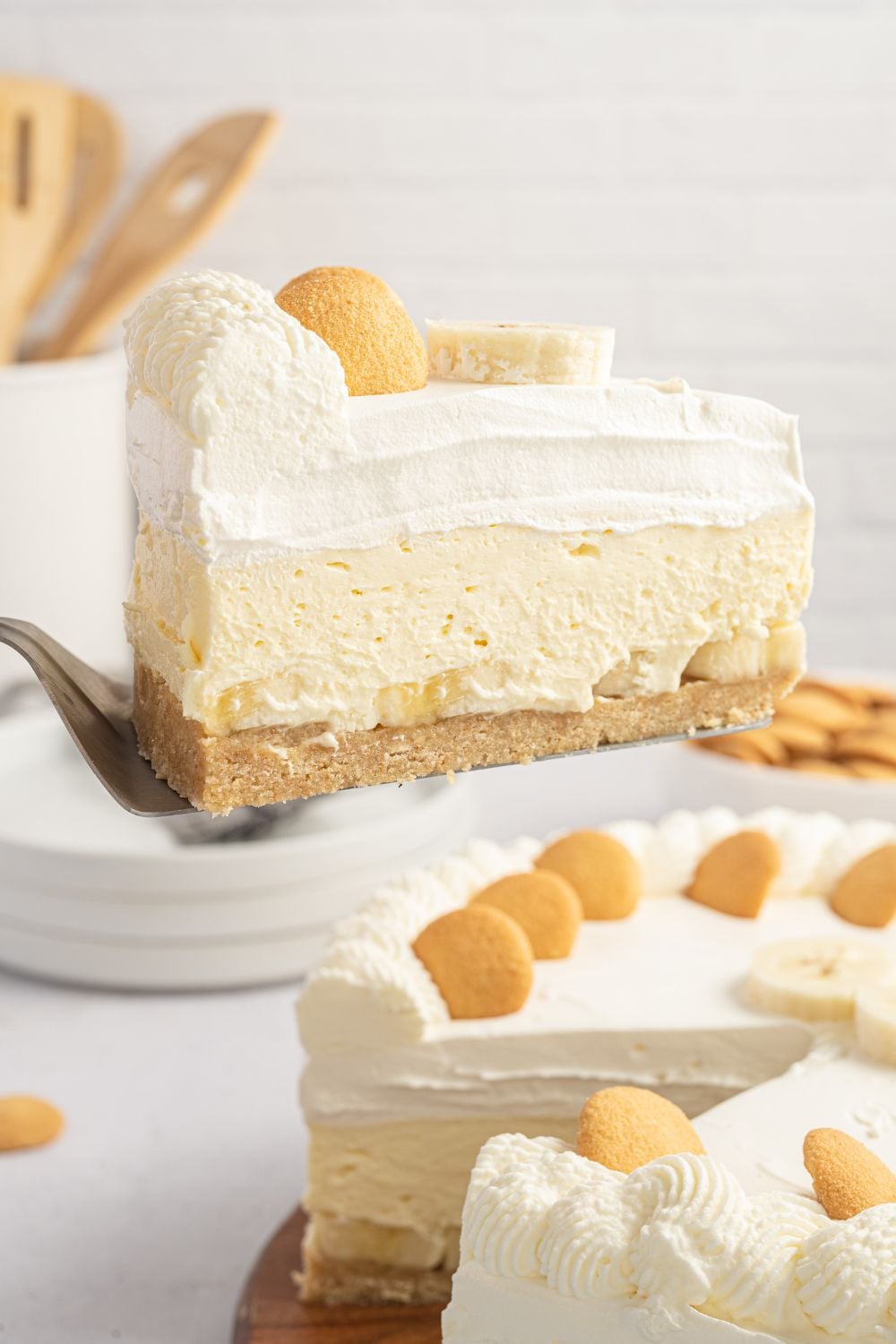 slice of banana pudding cheesecake on spatula being lifted out of the pie