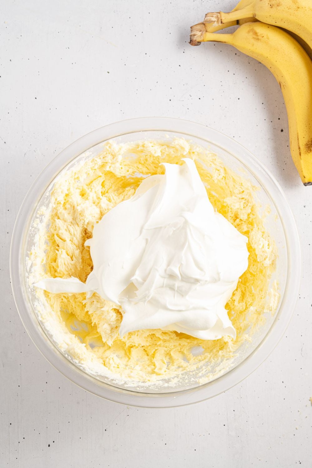 banana pudding filling mixed up with whipped cream in the center of the bowl