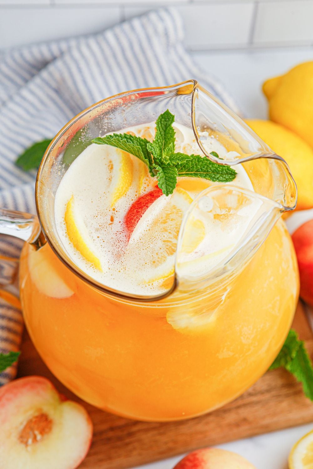 Peach Lemonade in a pitcher with a garnish on mint