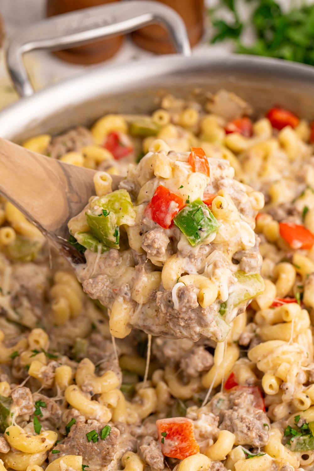 Philly Cheesesteak Pasta in skillet with a spatula scooping some pasta up 