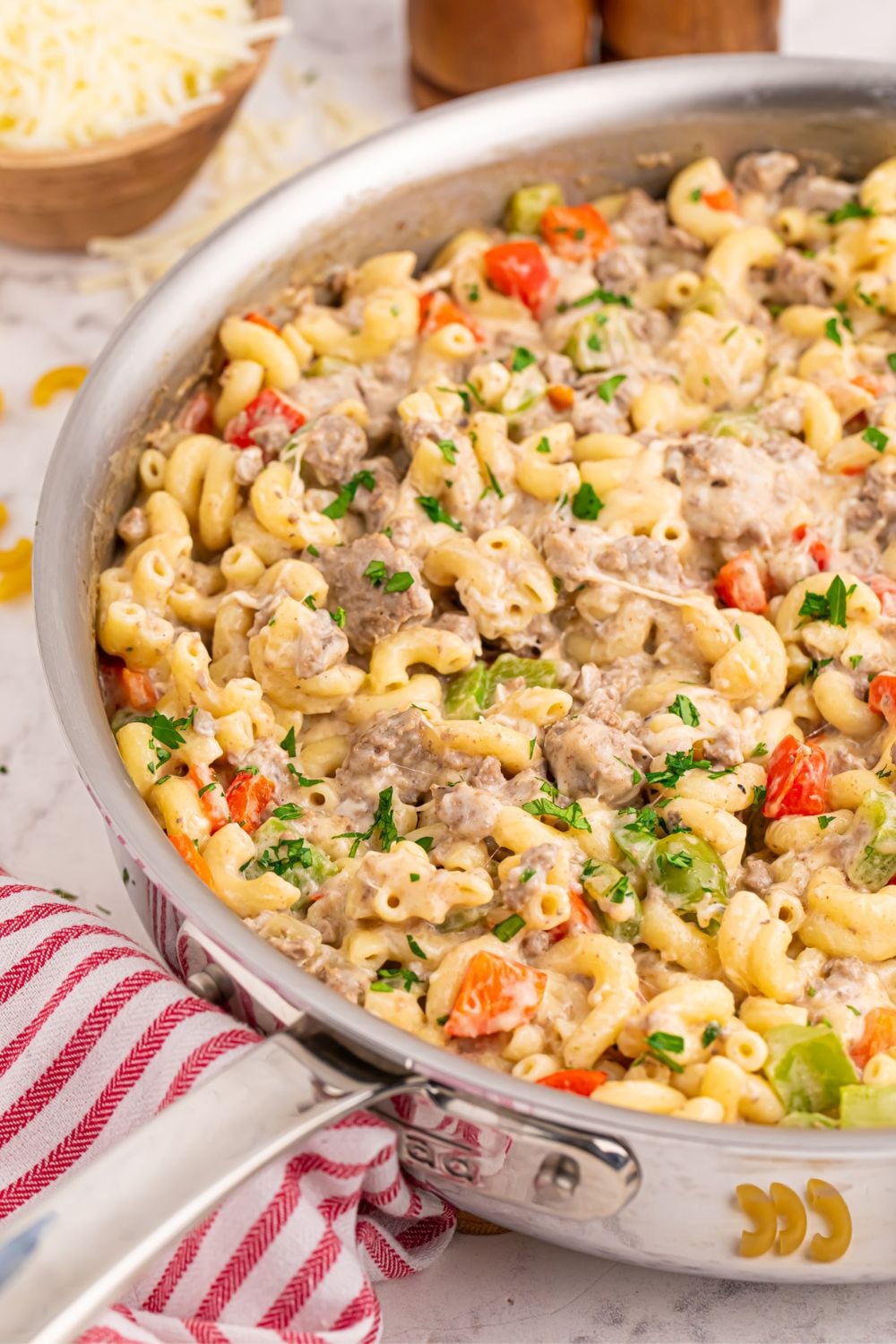 Philly Cheesesteak Pasta in a pan with a red striped towel on table by it 
