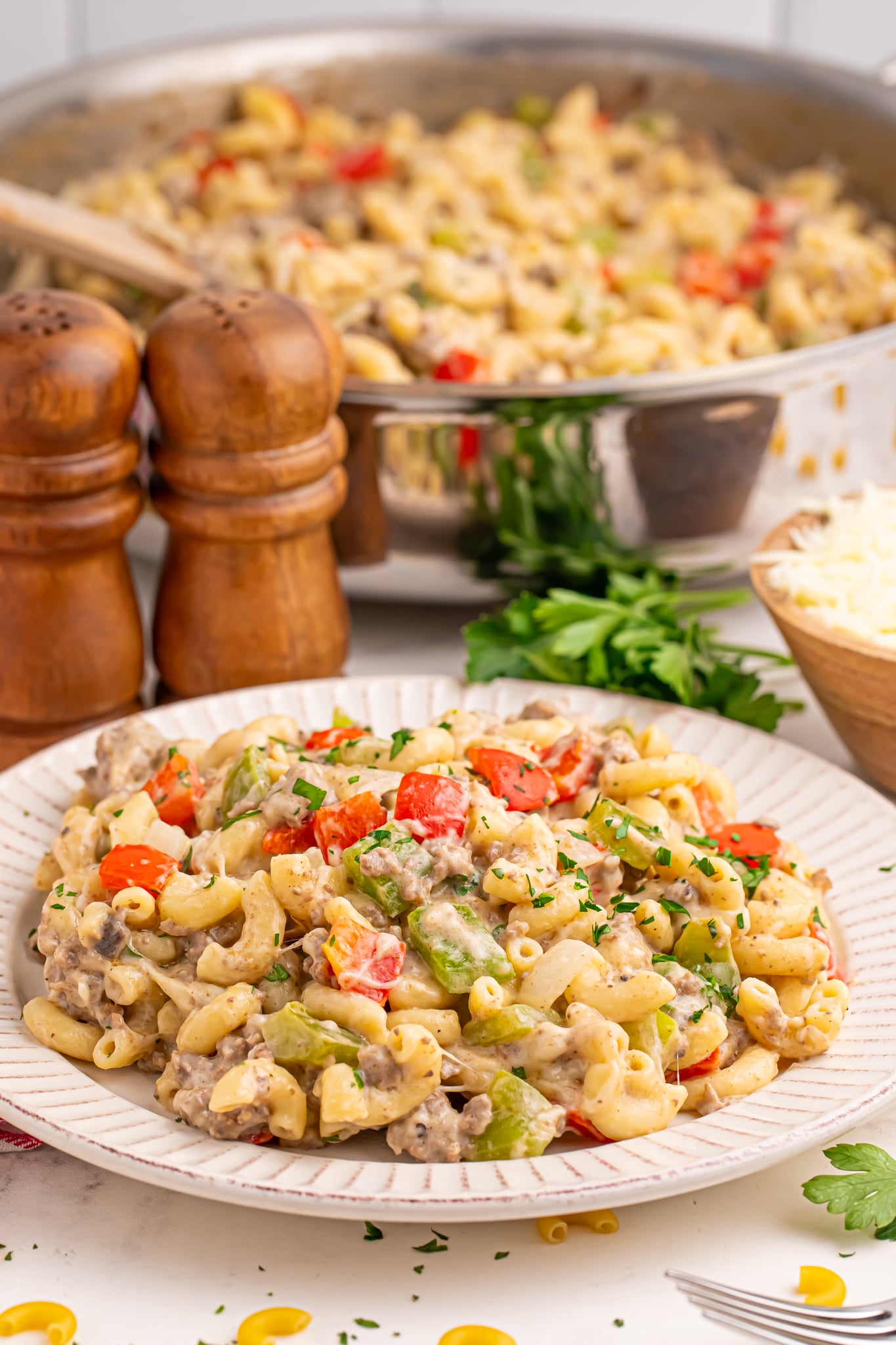 Philly Cheesesteak Pasta in a skillet in the background with a plate full in front 