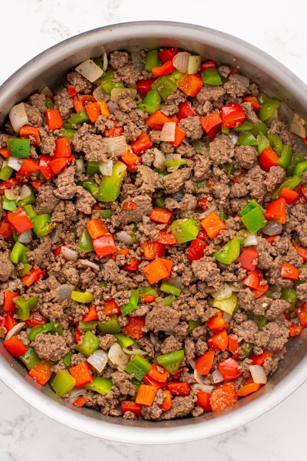 ground beef, diced peppers and onions in a skillet 