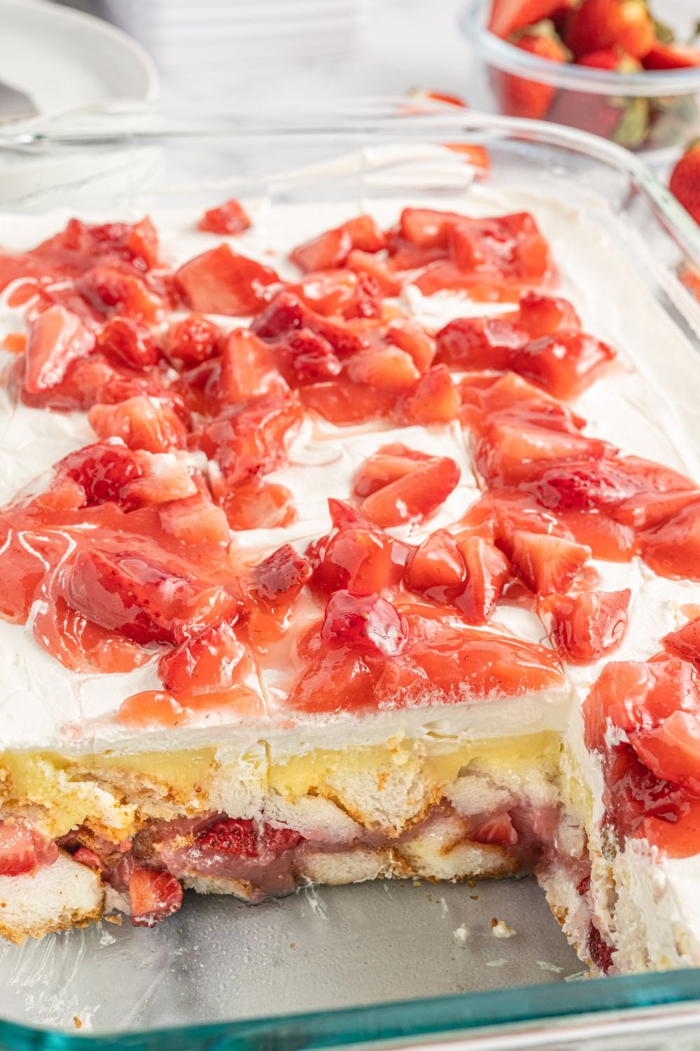 Strawberry Heaven On Earth Cake in pan with a few slices cut out to show the layers of the dessert in pan