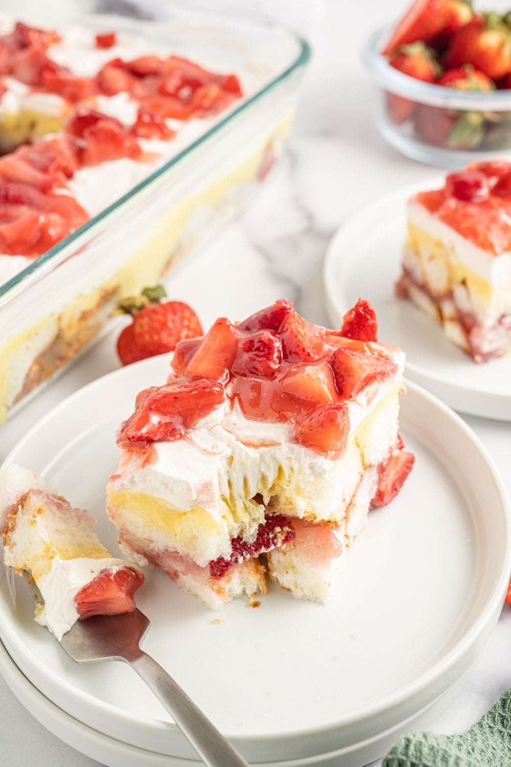 Strawberry Heaven On Earth Cake sliced on a plate with a fork with a bite full of it