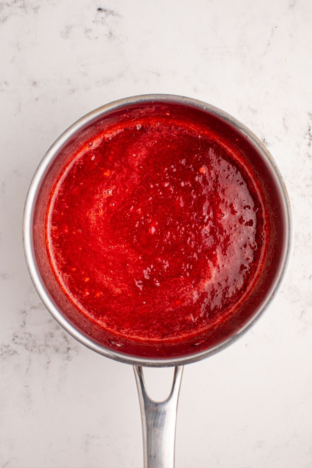 strawberry sauce in a saucepan on counter