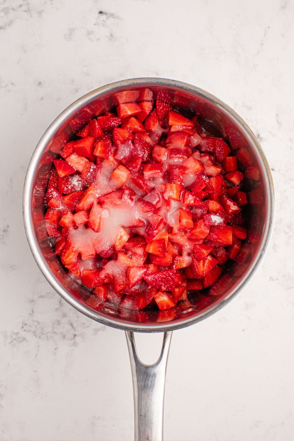 diced strawberries and sugar in a pan on counter