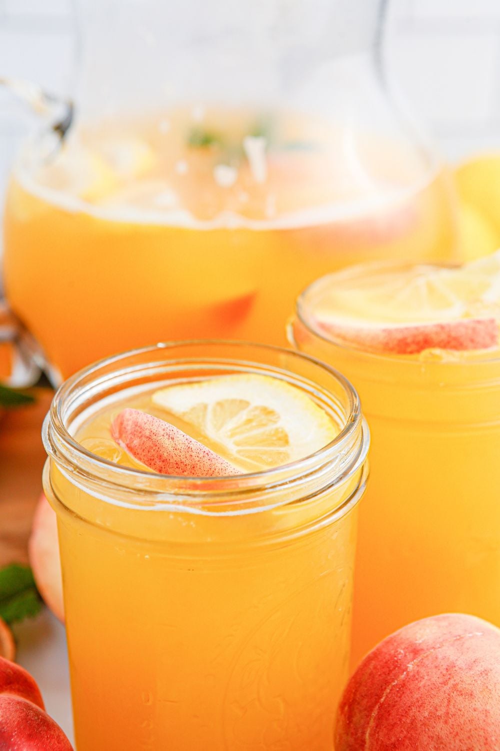 Peach Lemonade with sliced peaches and lemons in a glass