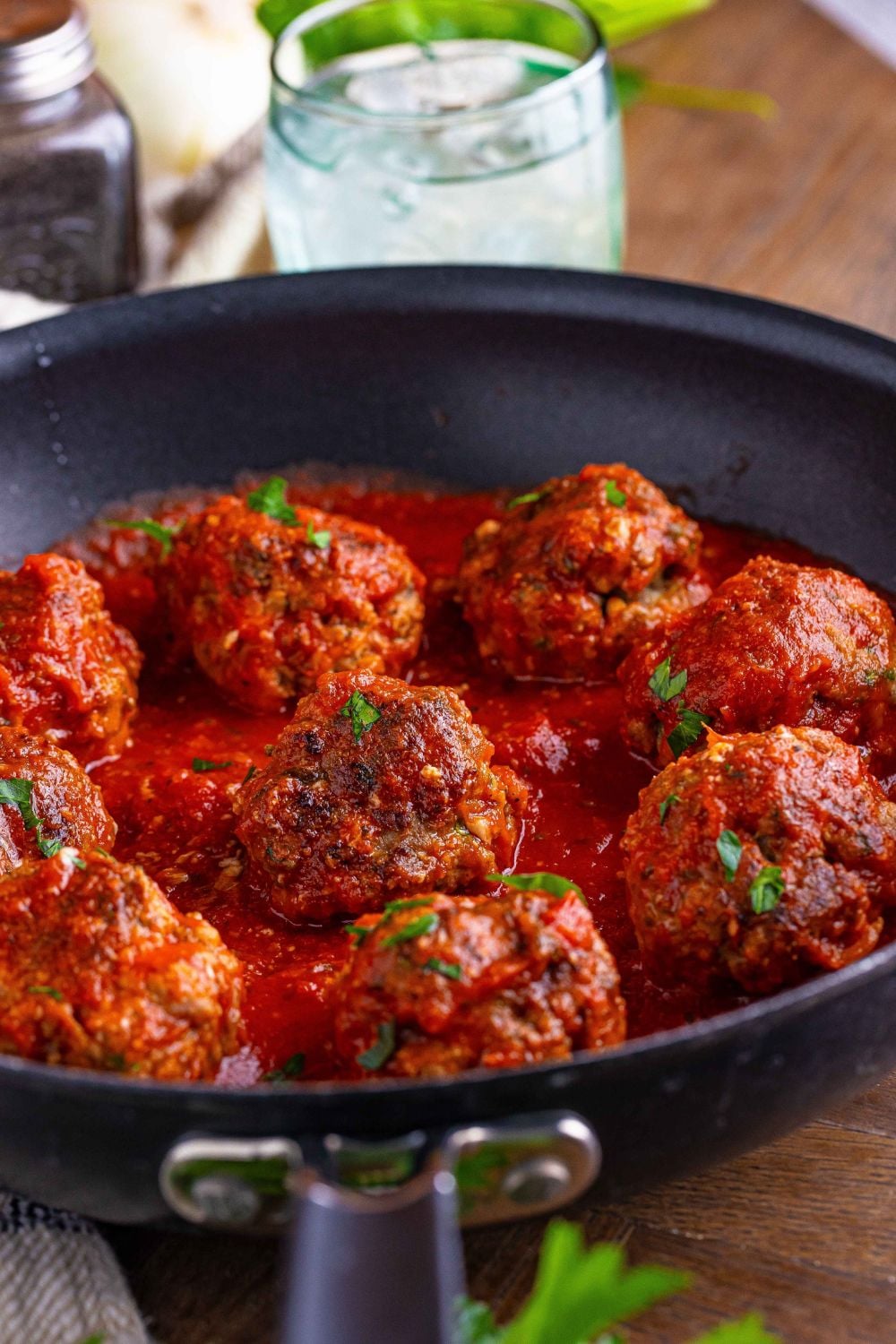black skillet with meatballs and sauce on a table 