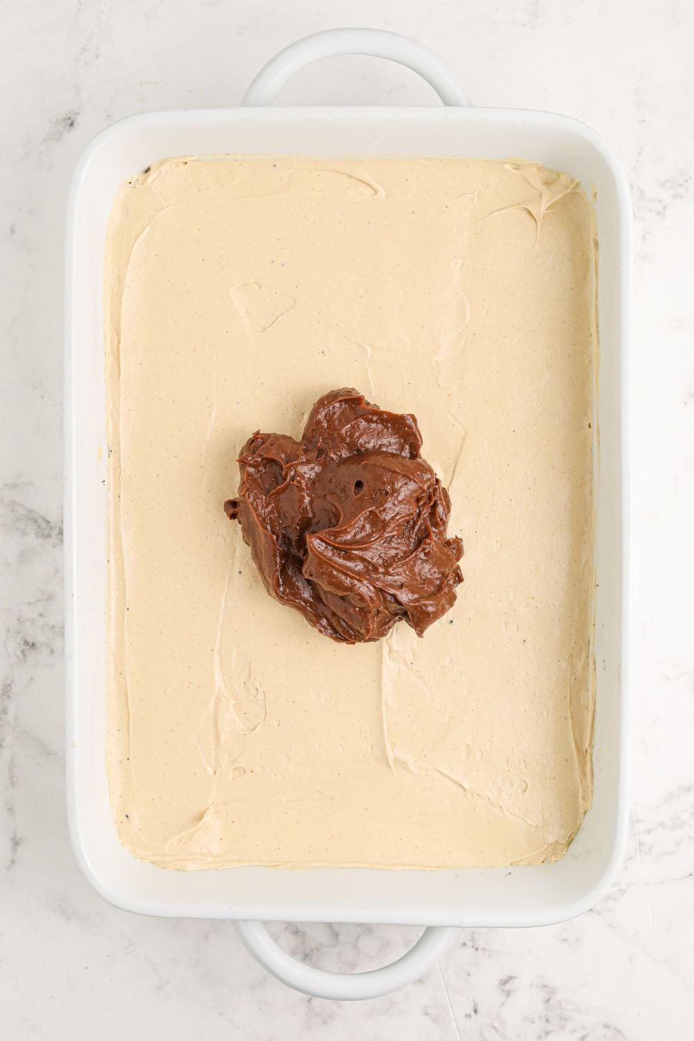 Reeses Lasagna with peanut butter cream cheese layer spread evenly then chocolate pudding in center
