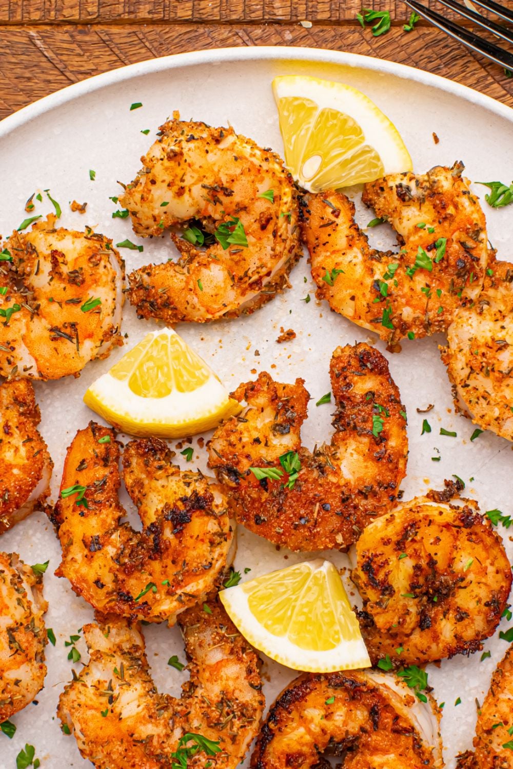 Cajun Grilled Shrimp spread out on a plate with sliced lemon on it