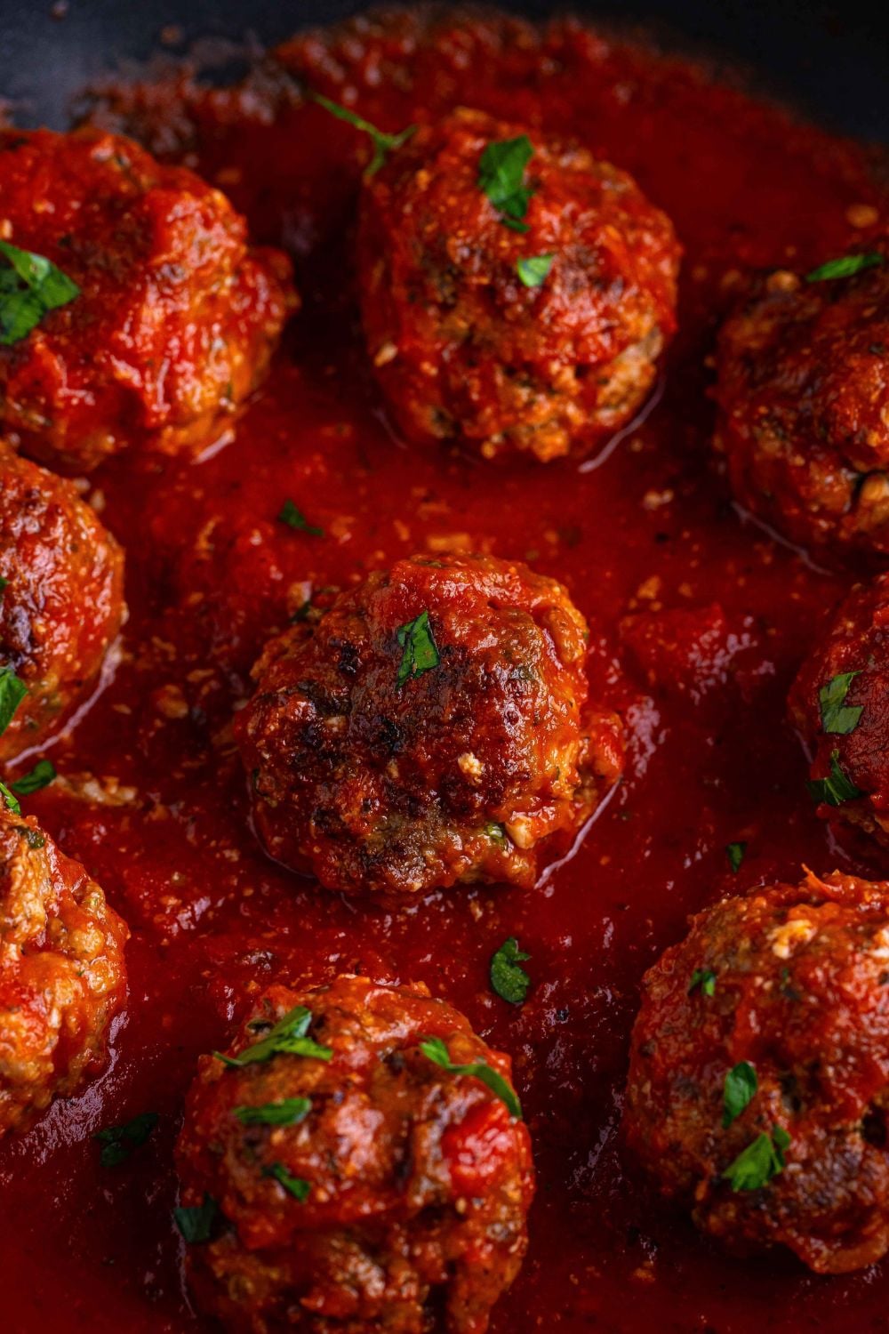 Classic Italian Meatballs close up in a pan with a marinara sauce drizzled on top 