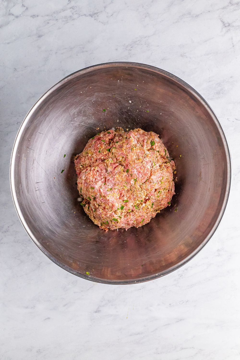 raw meatball mixture in a metal bowl 