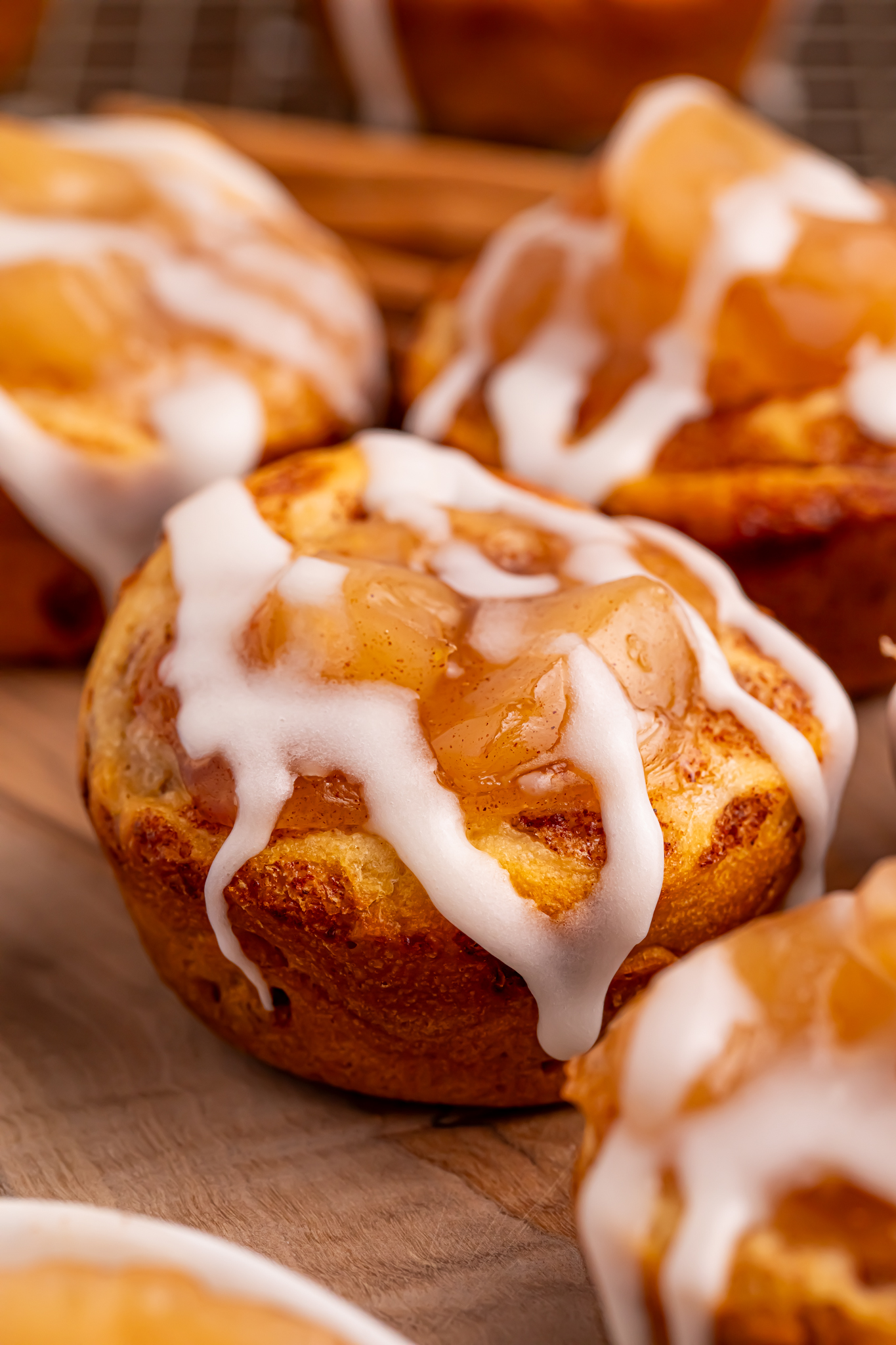 apple pie cups on table with a close up of the pie filling and icing on top