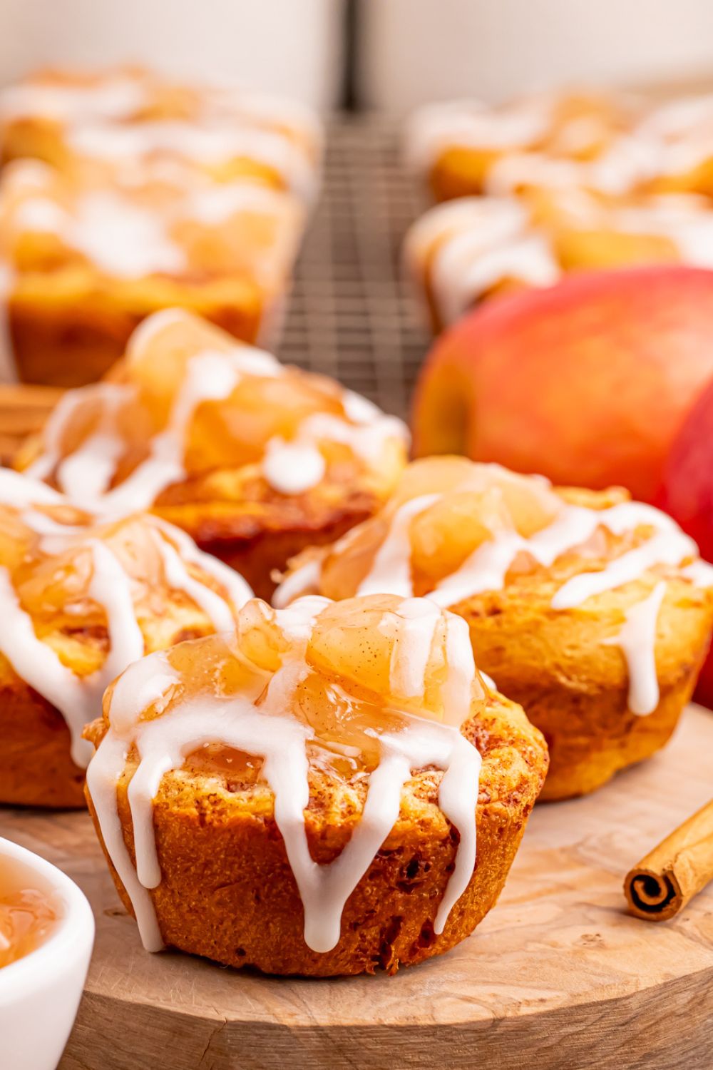 Easy Apple Pie Cups on a round tray with more cups placed in the back of image with an apple to the side