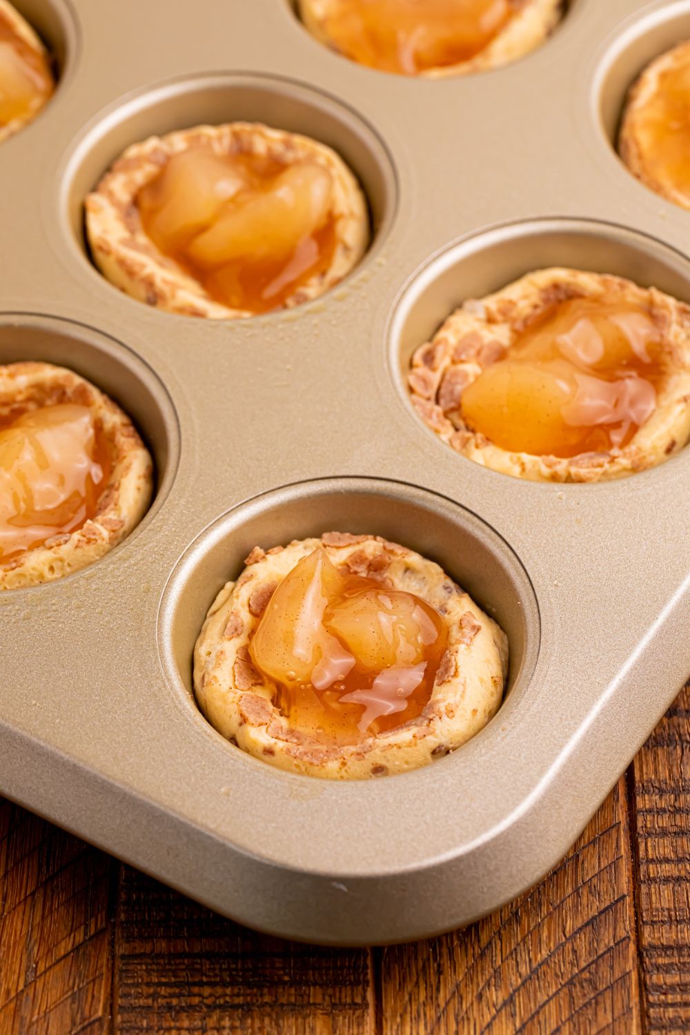 raw Apple Pie Cups in muffin tin with some apple pie filling in center