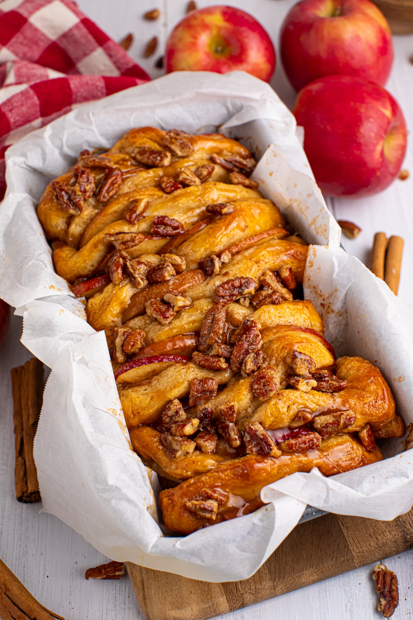 Apple Pie Pull Apart Bread in a pan topped with nuts and caramel sauce
