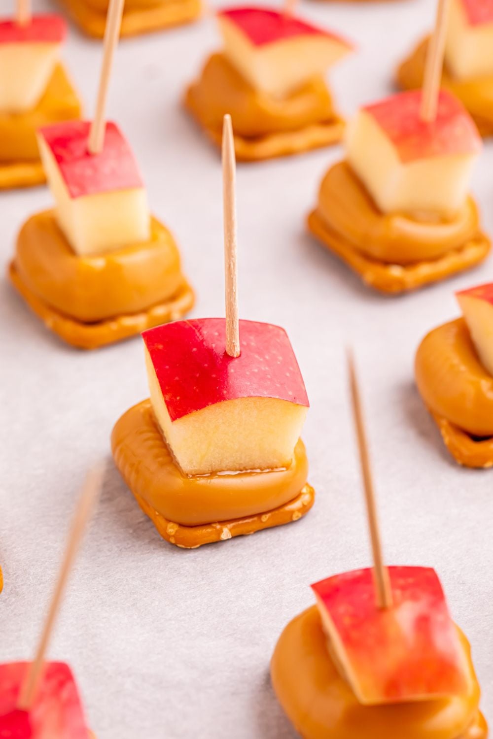 caramel apple bites on toothpicks sitting on a cookie tray