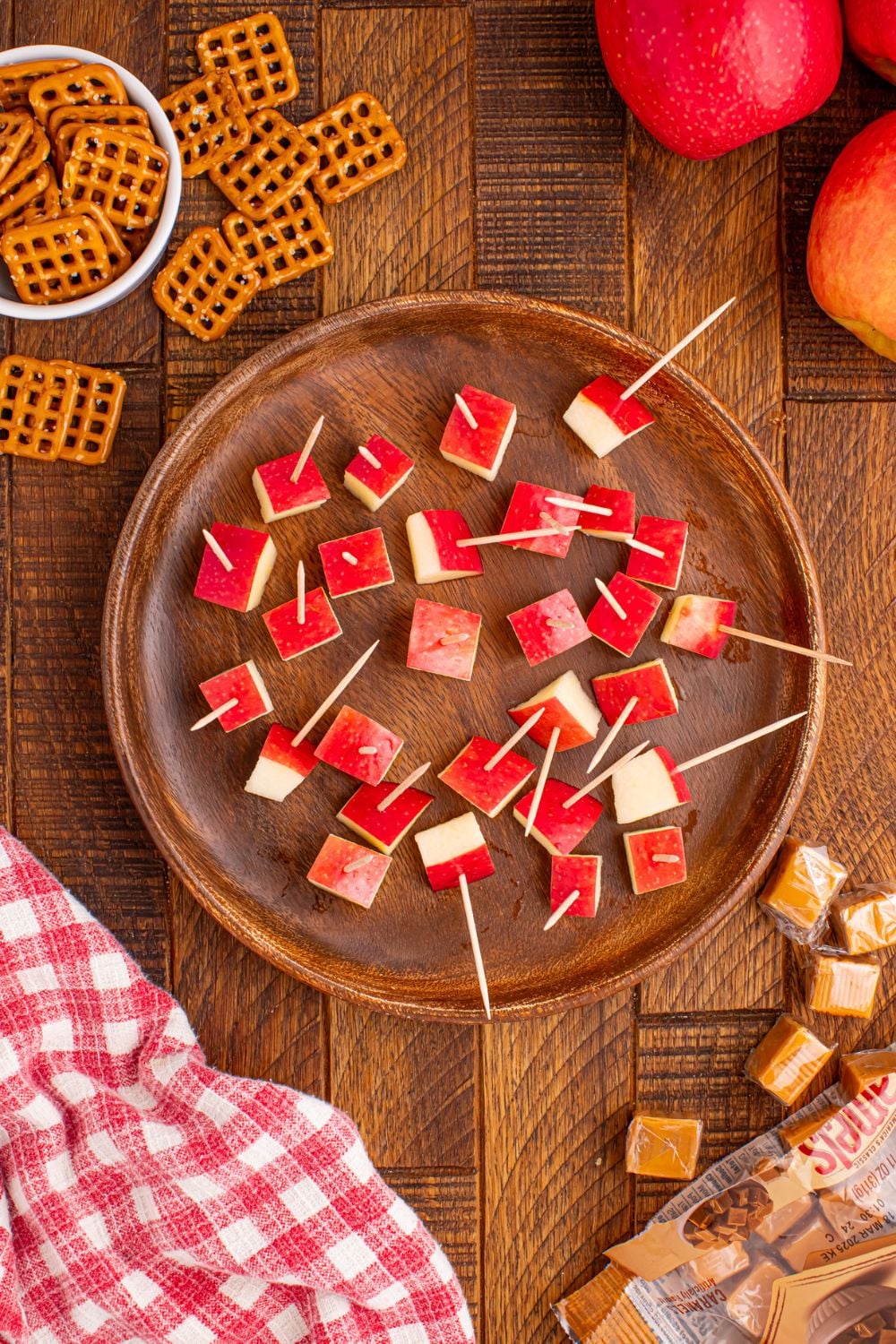 diced apples with pretzels in them sitting in a bowl on table