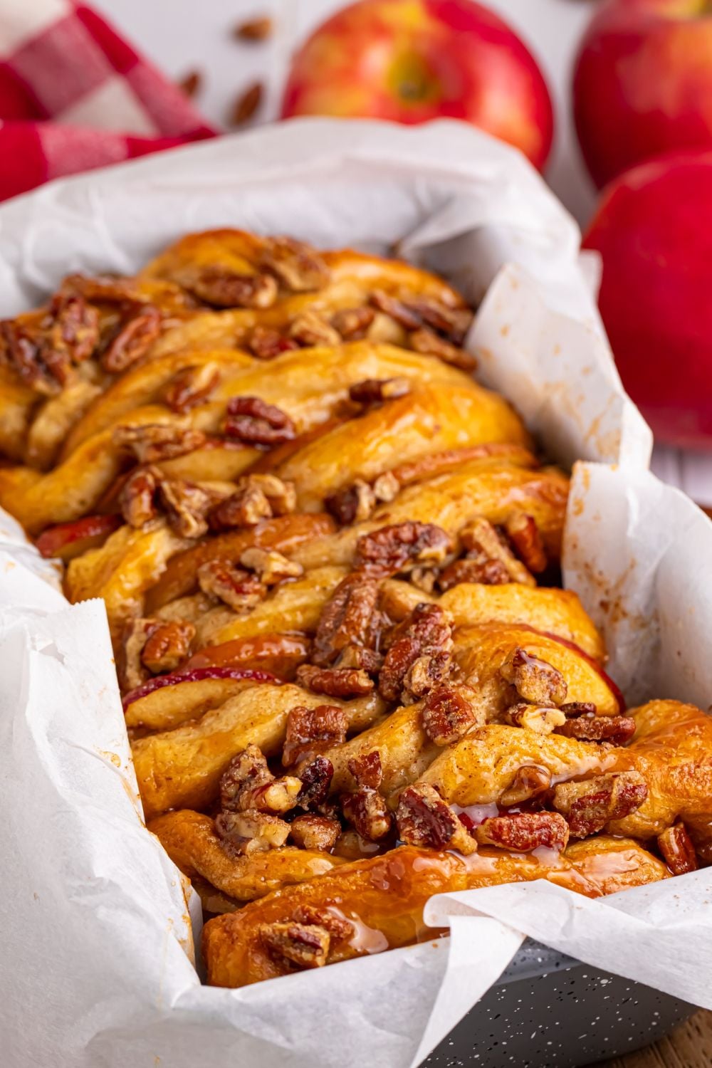 Apple Pie Pull Apart Bread in a pan with parchment paper in it sitting on a table
