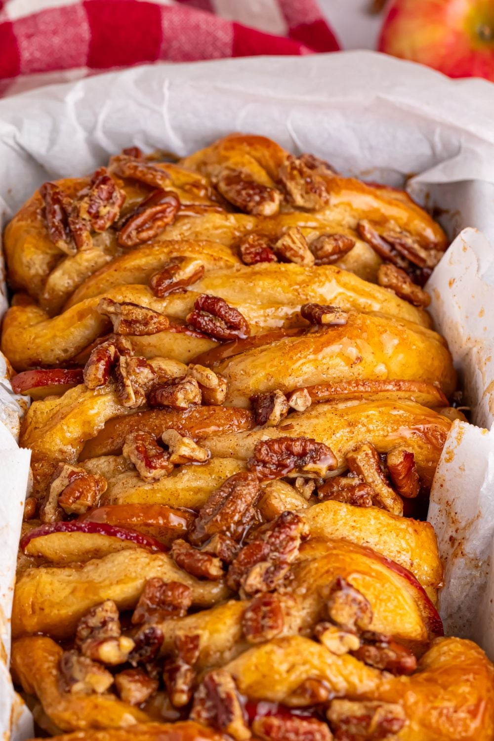 Apple Pie Pull Apart Bread in a pan with a close up of nuts on top