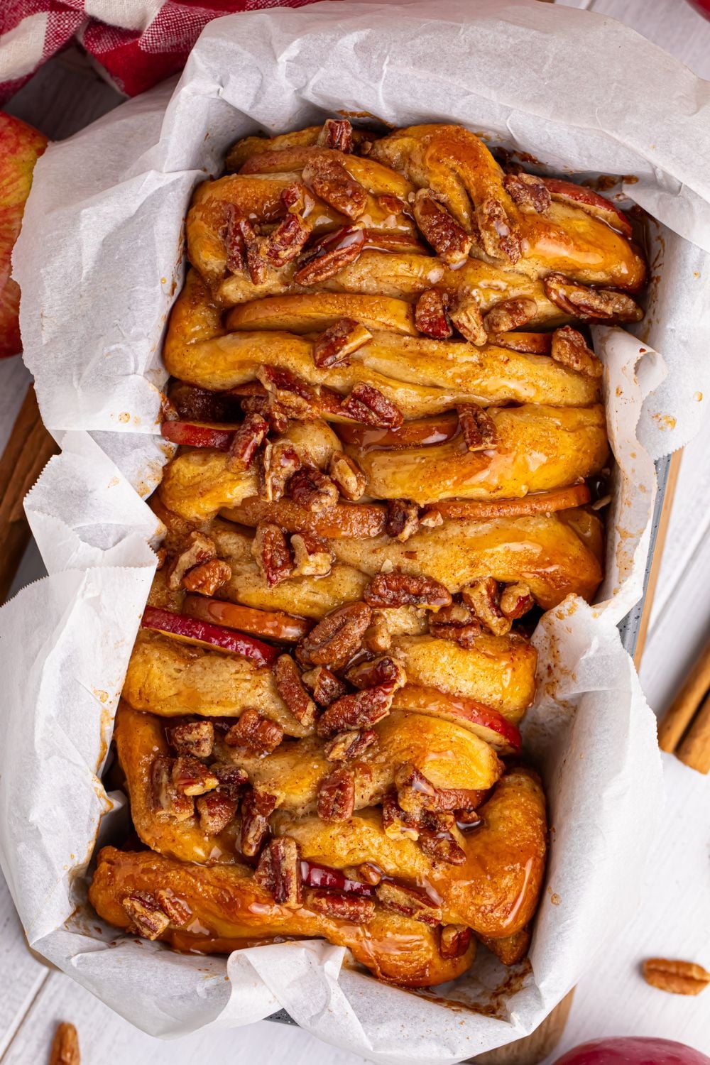 Apple Pie Pull Apart Bread on table in a pan with parchment paper on the sides