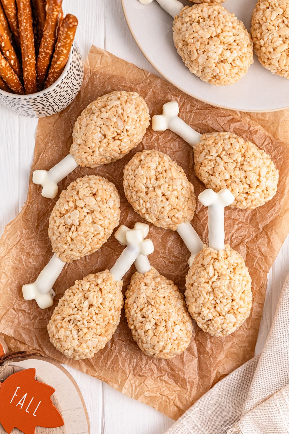 table with Rice Krispie Treat Turkey Legs spread around with pretzel rods and other ingredients around it in bowls